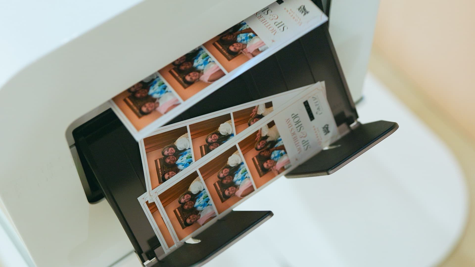 Two guests laughing together while holding their Luxpiq photo booth prints