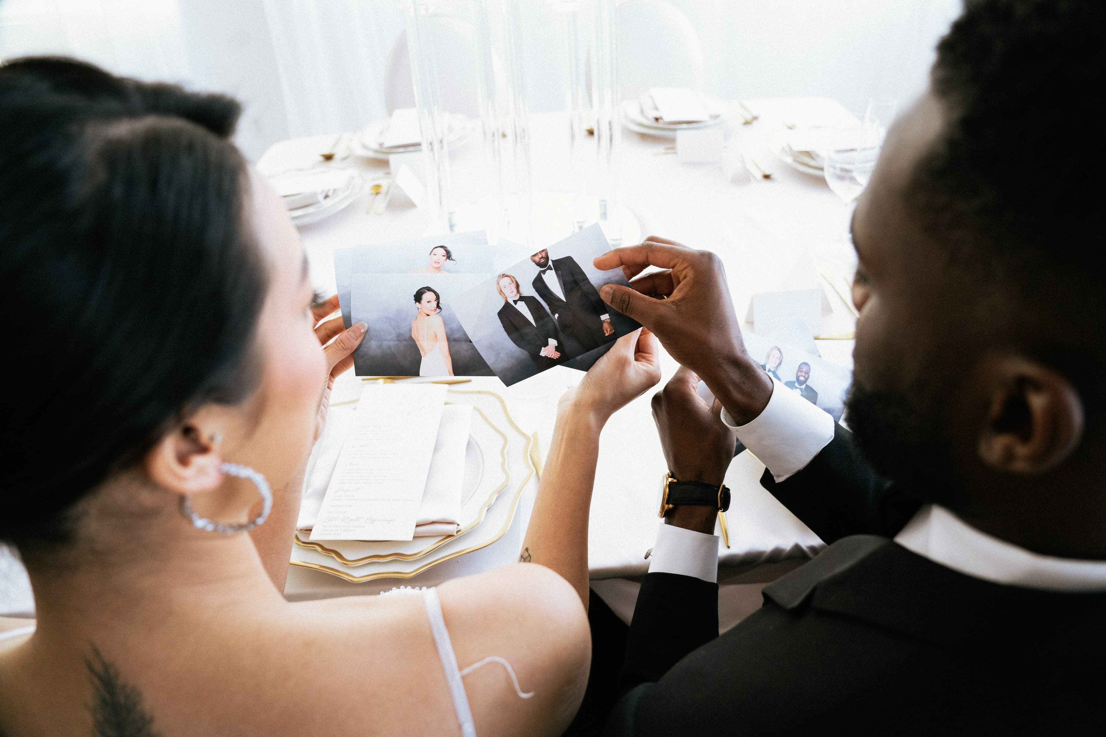 Couple at a wedding reception looking at their photo booth prints